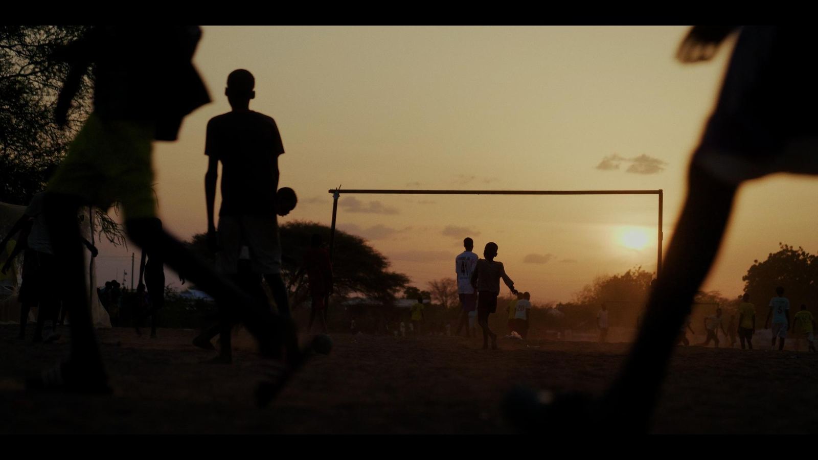 Figures at a goalmouth at dusk