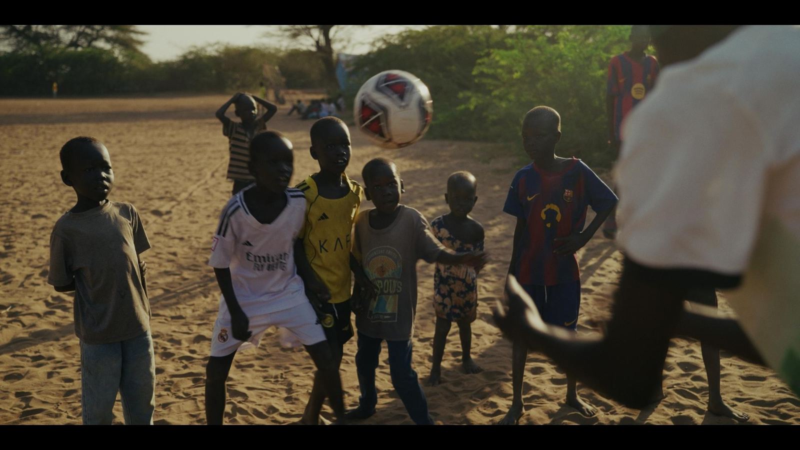 Children playing football on sand